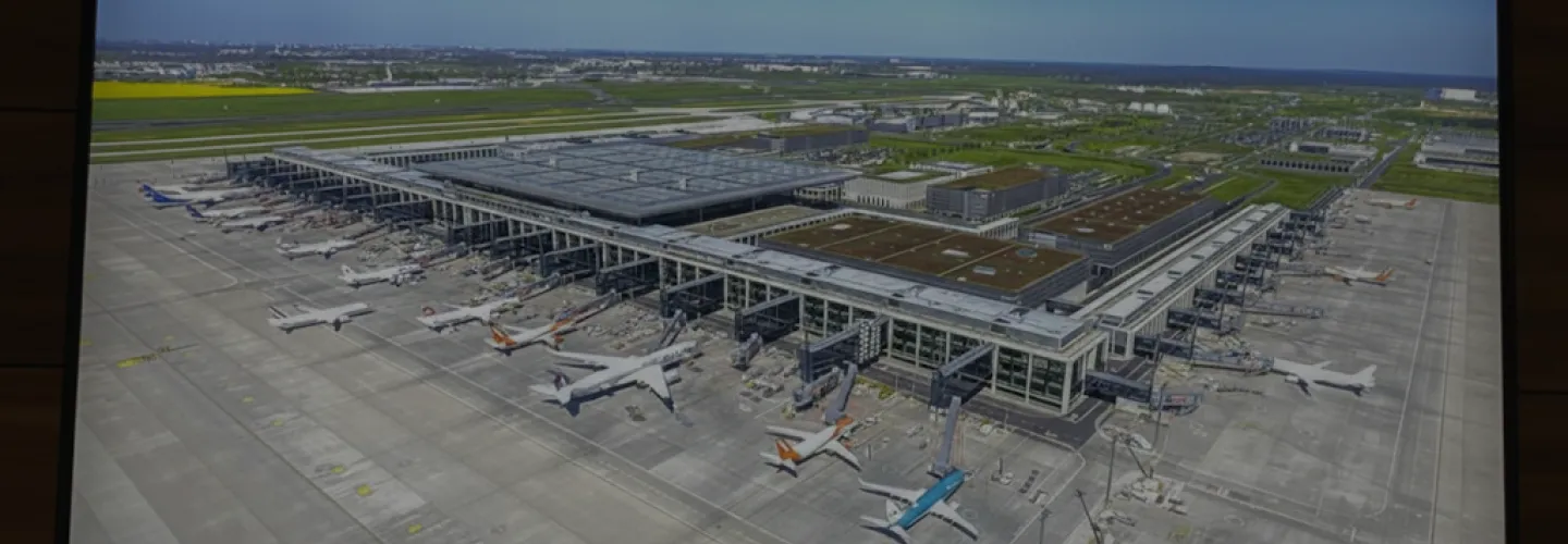 Luftaufnahme des BER mit Terminalgebäude und abgestellten Flugzeugen am Gate