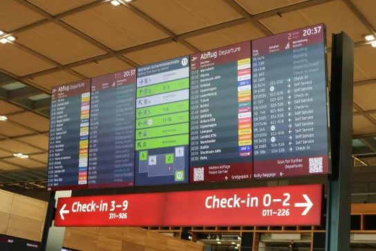Anzeigetafel mit Abflugzeiten, Sicherheitskontroll-Wartezeiten und Check-in-Hinweisen im BER